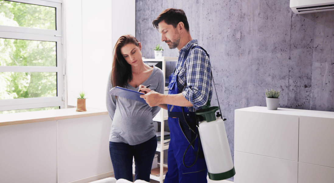 a man holding a checklist and carrying a spray for pest next to the pregnant lady