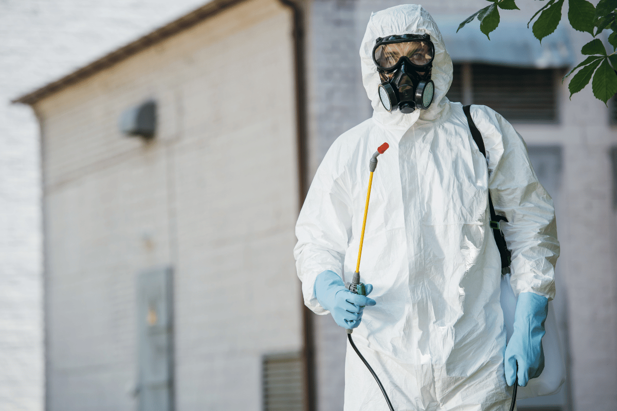 male holding a probe , white jump suit , bottle on his back