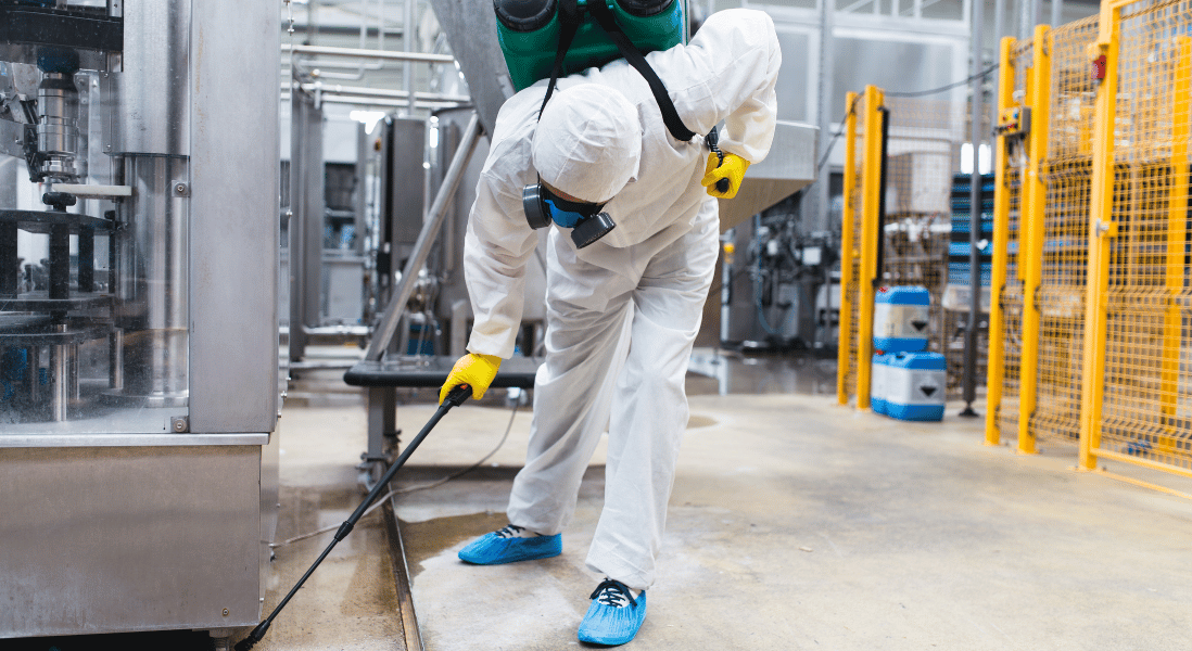 a male wearing a white jump suit , yellow gloves , bottle behind his back