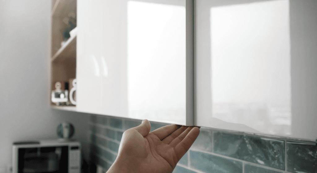 hand touching underneath the cupboard doors